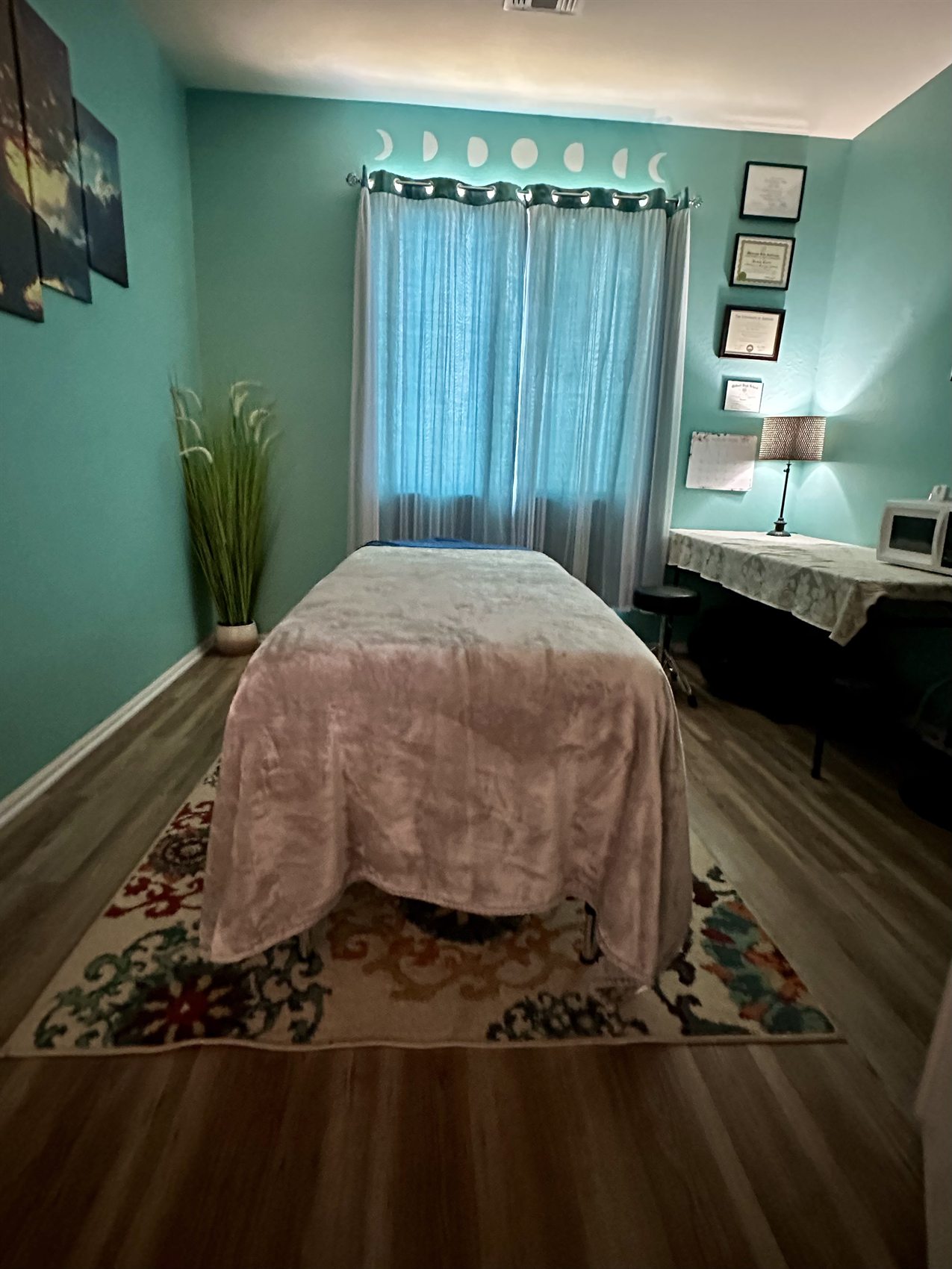 Window curtains and moon phase decor in the massage room.